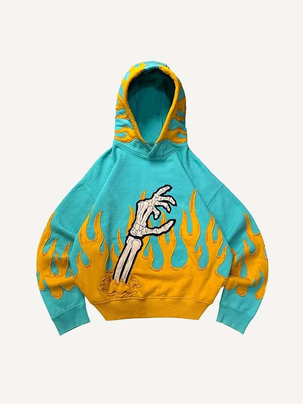 Sudadera con capucha y bolsillos inclinados con estampado de calavera, palmeras y fuego en bloques de color 